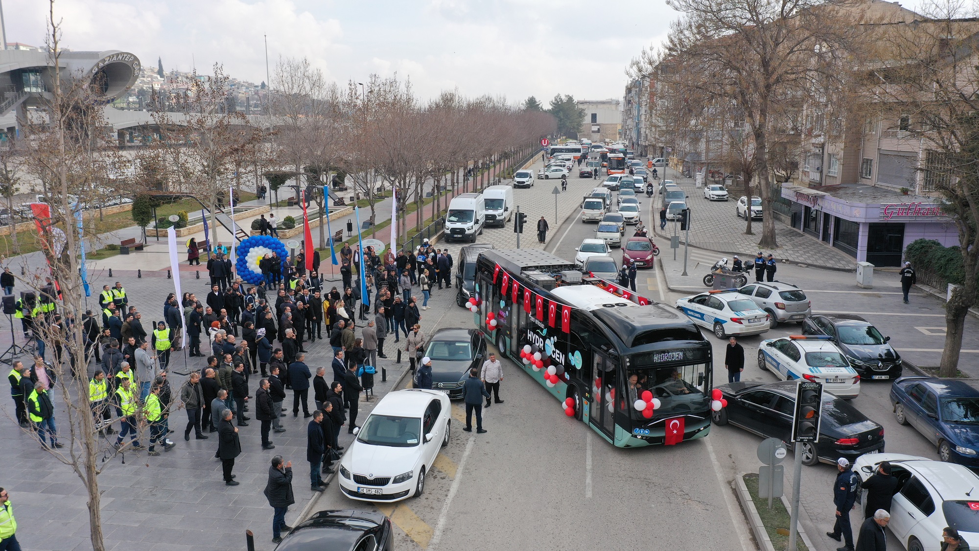ÇEVRE DOSTU ULAŞIM ÇÖZÜMLERİ ARTARAK DEVAM EDİYOR
Son yıllarda büyükşehir belediyeleri, ulaşım altyapılarını modernize ederek çevre dostu çözümler geliştirmeye devam ediyor. Şanlıurfa Büyükşehir Belediyesi, elektrikli otobüs alımı ve eski araçları elektrikli sisteme dönüştürme projeleri ile önemli bir adım atarken, Gaziantep de ulaşım sisteminde önemli bir dönüşüm sürecine girmiş bulunuyor. Mevcut 363 turuncu otobüs ve 53 tramvayla hizmet veren Gaziantep, fosil yakıt kullanımını azaltarak daha çevreci sistemlere geçiş yapmayı hedefliyor.
